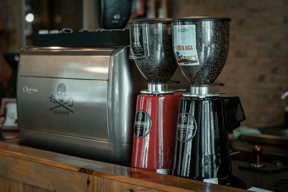 Espresso burr grinder alongside espresso equipment