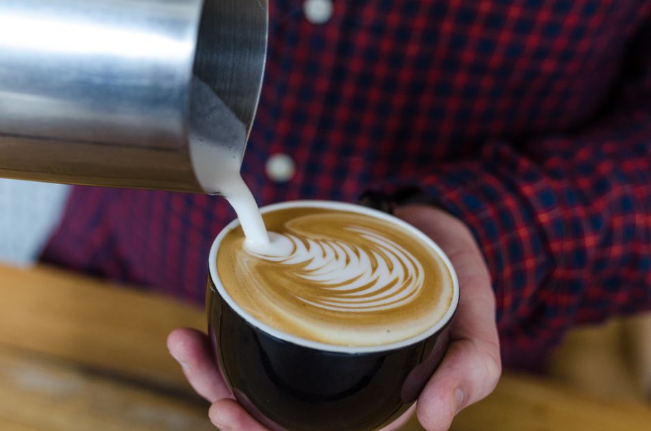 Steamed milk poured into espresso forming latte art
