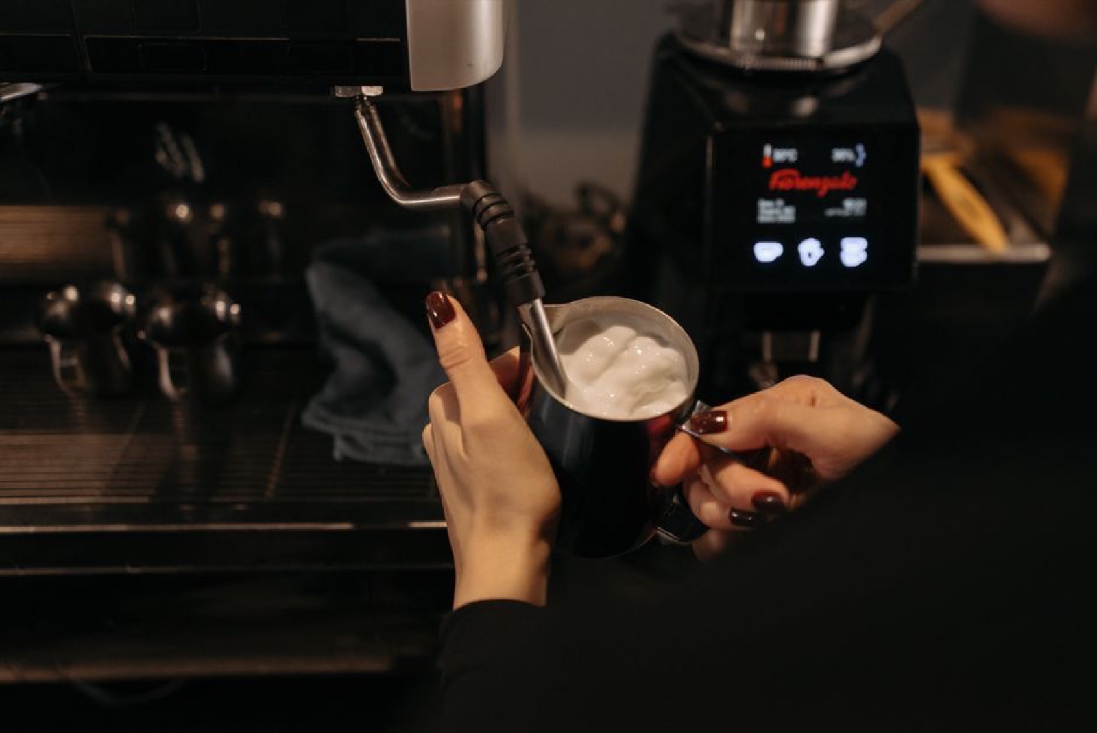 Home espresso machine setup on kitchen counter with coffee beans and cup