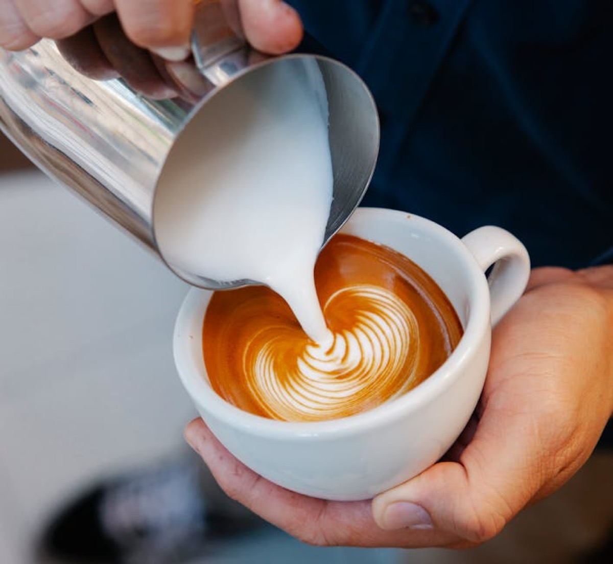 Barista pouring steamed milk for latte art