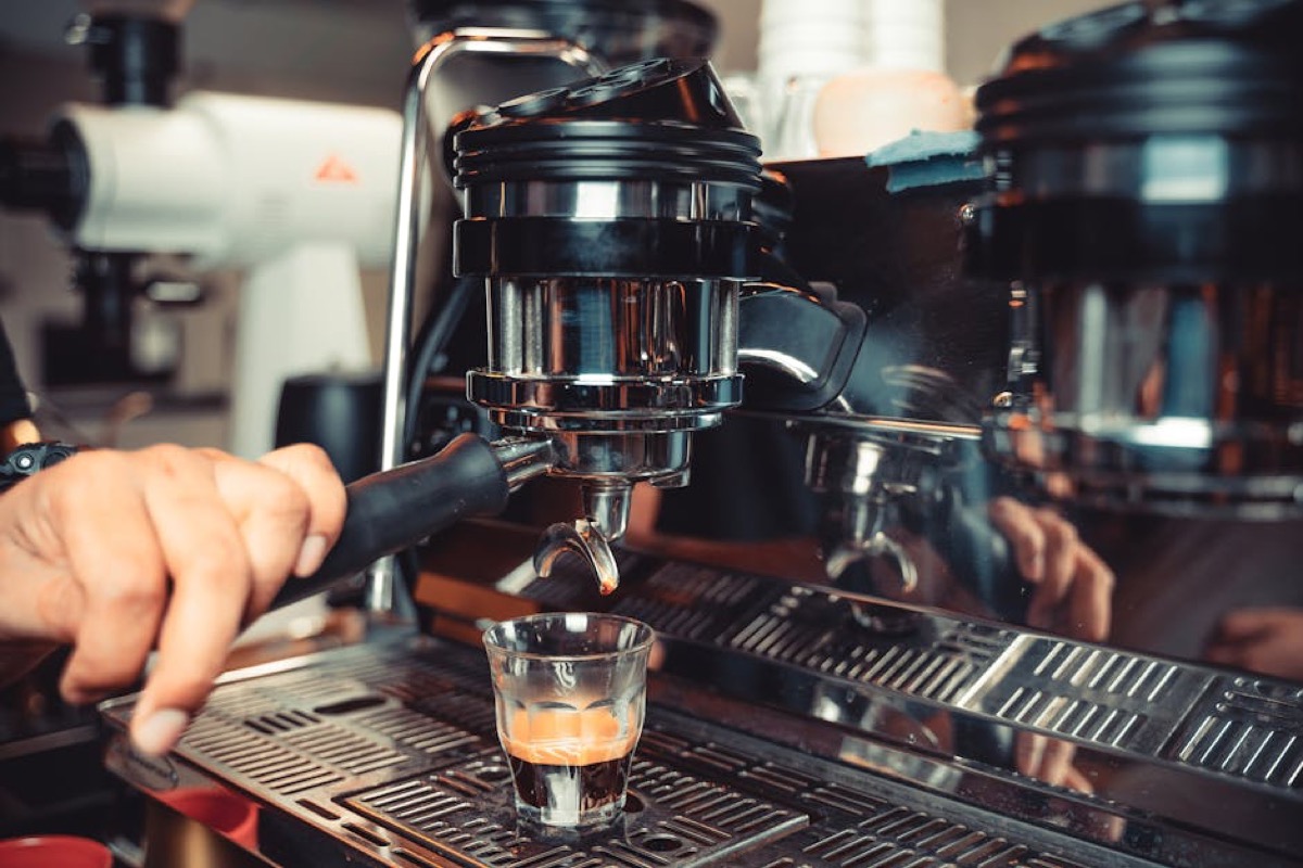 Barista using espresso machine portafilter in cafe workflow