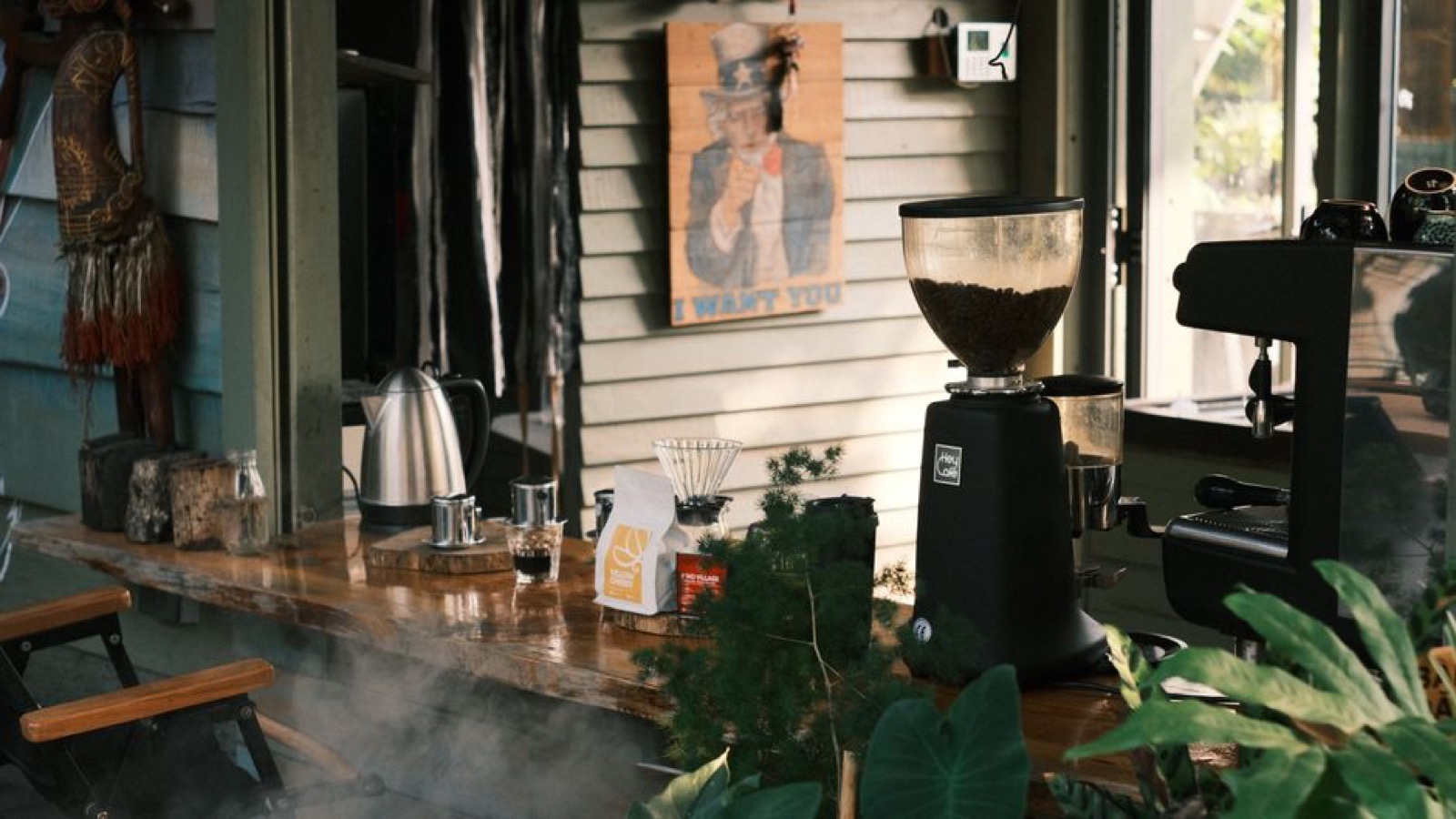 Modern espresso grinder next to espresso machine in cafe setting
