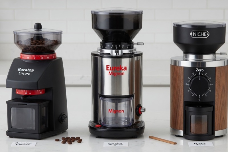 Three dedicated burr coffee grinders lined up on a countertop, illustrating the range of grinders built for espresso and drip coffee