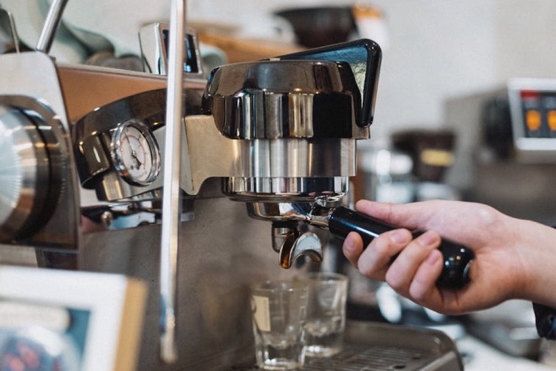 Espresso shot pulling from a portafilter showing golden crema, the visible result of consistent grind particle size