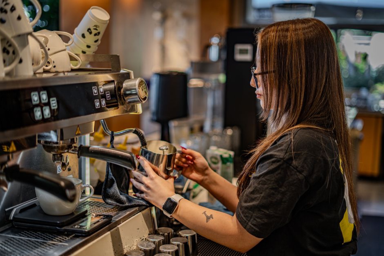 Barista steaming milk at a prosumer espresso machine - single-boiler workflow